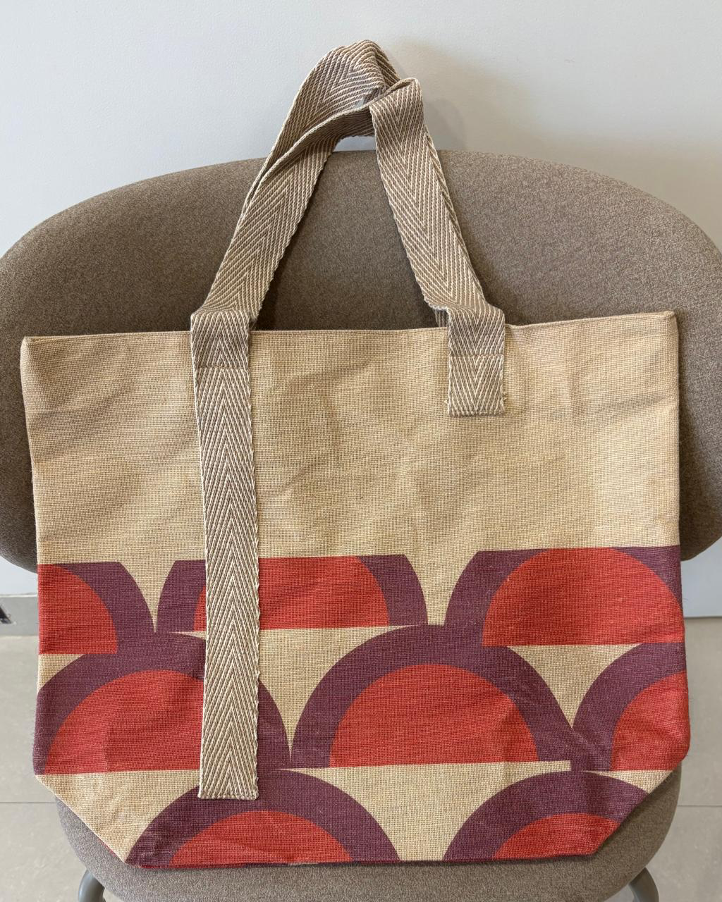 Veronica jute-cotton bag in a rust and plum geometric arc print.