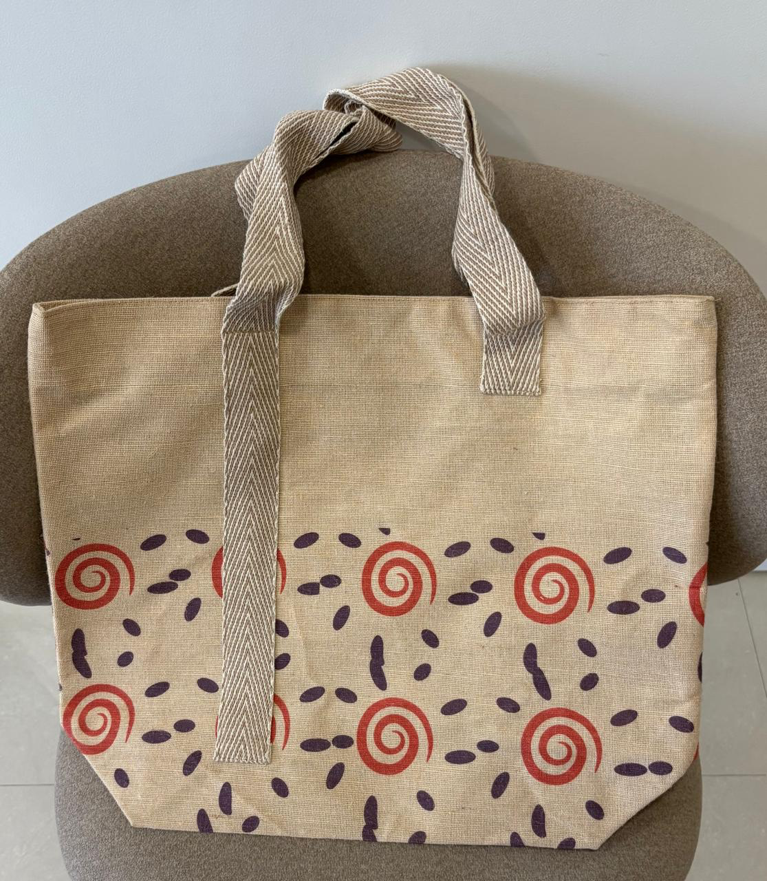 Veronica jute-cotton bag in a rust and plum spiral print.