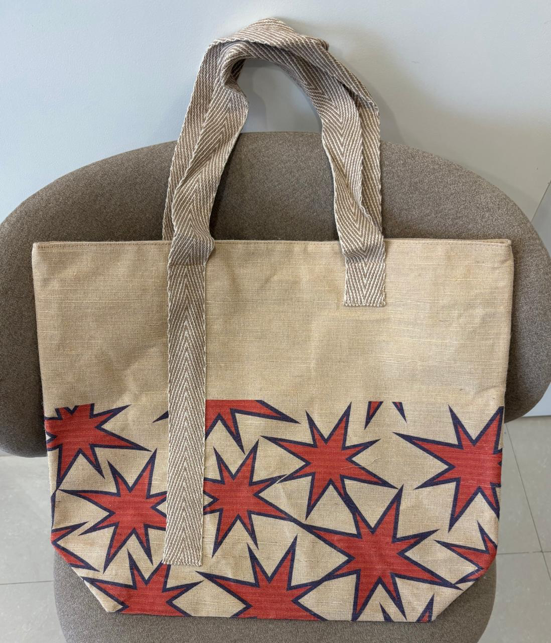 Veronica jute-cotton bag in a rust and navy starburst print.